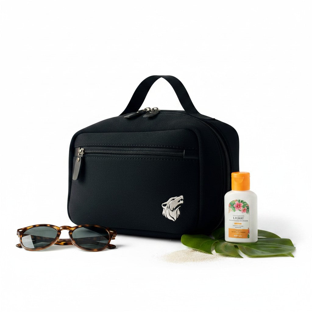 likemoon.shop The Bag, a compact black padded toiletry bag for men with a wolf logo, shown with sunglasses and lotion.